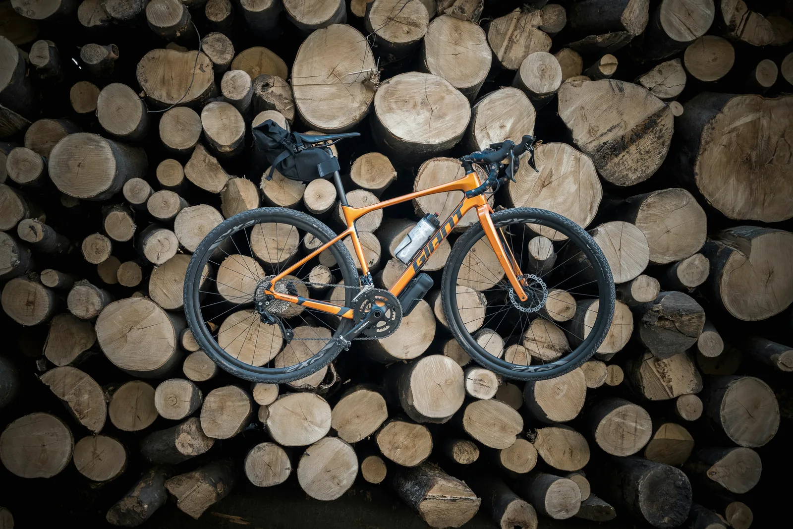 Gravelbike vor Holzstapel